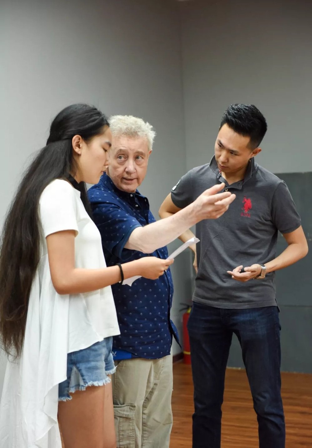 Paul Wagar giving notes to two actors holding scripts